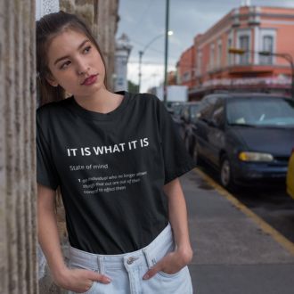 Woman wearing a black IT IS WHAT IT IS T-shirt from Yebber, featuring bold typography and a dictionary-style definition—statement clothing for a carefree mindset.