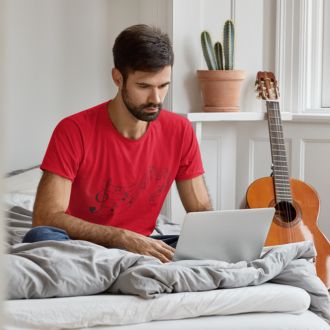 Man wearing a red Love Music Sheet T-shirt from Yebber, featuring a heart-shaped music sheet design – statement clothing for music lovers.