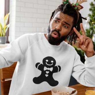 Person wearing a white Minimalistic Christmas statement clothing sweatshirt with a black gingerbread man design, making a playful peace sign gesture while sitting at a holiday breakfast table.