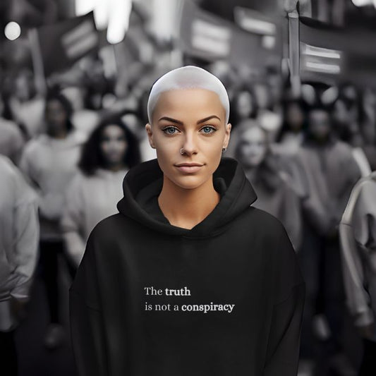 Person wearing a black Bold Truth statement clothing hoodie with the text "The truth is not a conspiracy" in bold white font, standing confidently in front of a blurred crowd. Premium DTG print quality, fast delivery, and free worldwide shipping by Yebber.