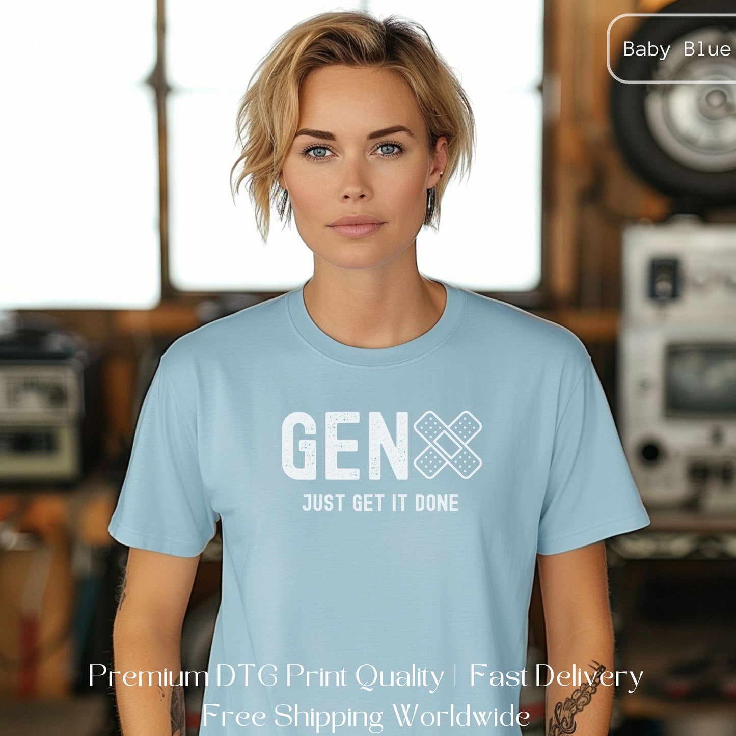 Woman wearing a baby blue Gen X statement clothing T-shirt with the text "Just Get It Done," standing in an industrial setting. Premium DTG print quality, fast delivery, and free worldwide shipping by Yebber.