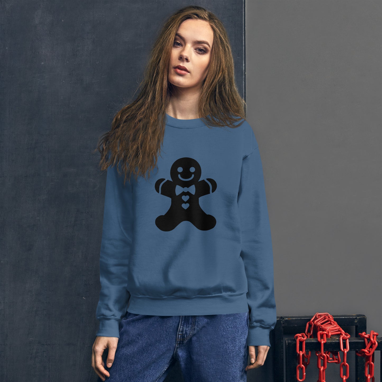 Person wearing a Indigo Blue Minimalistic Christmas statement clothing sweatshirt with a black gingerbread man design.