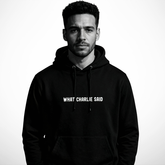 Man wearing the black “What Charlie Said” hoodie by Yebber in a minimalist studio setting – statement clothing that stands for truth and individuality.
