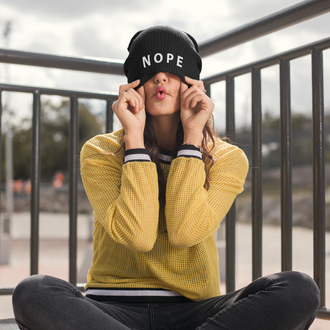 Person wearing a Nope Embroidered Beanie from Yebber, featuring bold embroidered text on a snug, stylish design – statement clothing for those with a bold attitude.